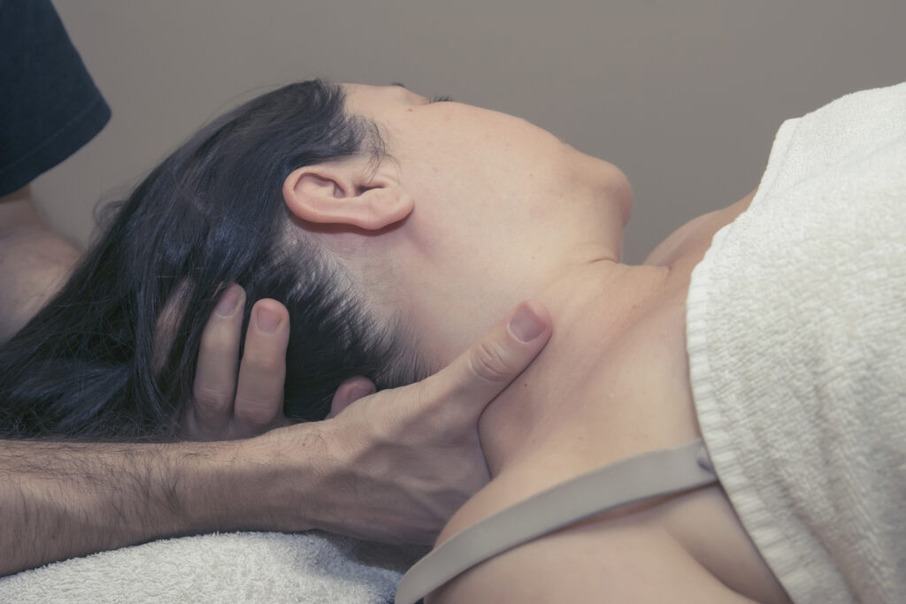 Imagen de un deportista recibiendo un masaje en el cuello